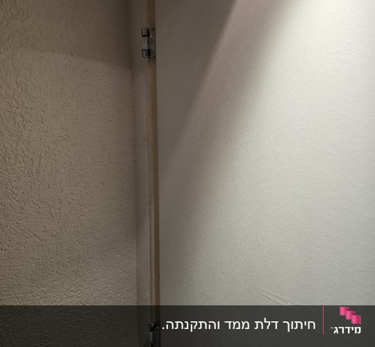 ציר דלת על קיר לבן עם תאורה רכה